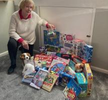 Rotarian Liz pictured with many of the toys destined for distribution around the area for Christmas.